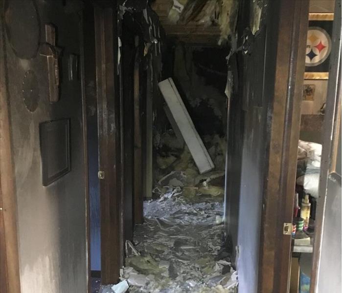 A hallway has been heavily damaged by fire.