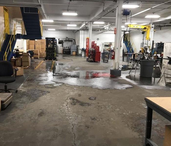A warehouse floor has standing water on it.