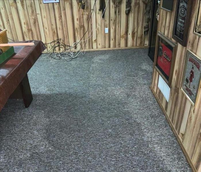 A basement has a wet carpet.