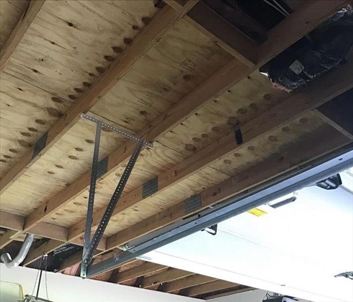 A garage ceiling has it's ceiling taken down.