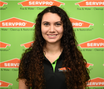 Image of female sitting in front of SERVPRO backdrop