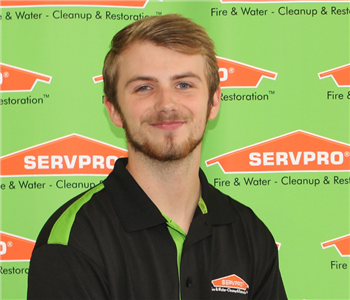 a man in front of SERVPRO banner