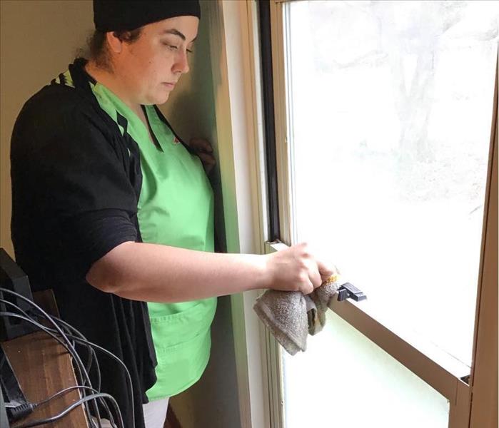 SERVPRO team member is wiping a windowsill.