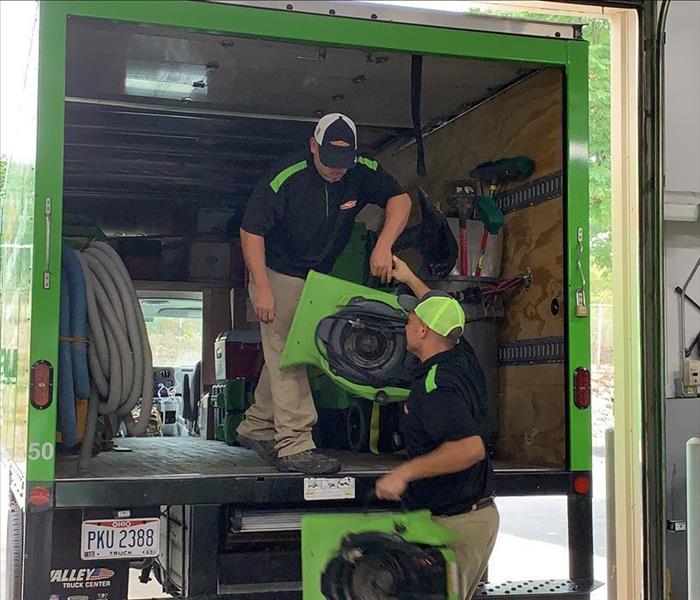 SERVPRO team members are unloading equipment from a truck.