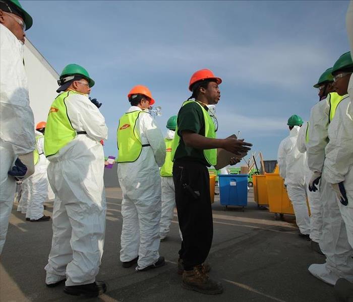 image of several SERVPRO technicians in PPE equipment and hardhats waiting to perform mitigation on a large loss job